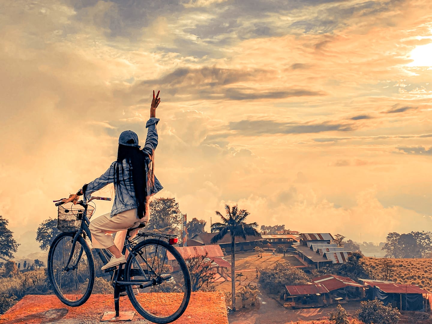 Huésped en bicicleta saludando al refugio desde el mirador, al atardecer